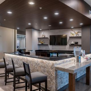 A modern bar interior with a sleek countertop and comfortable seating.