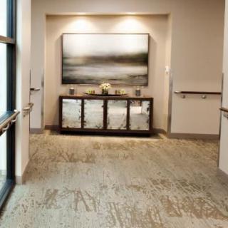 A modern hallway featuring artwork and decorative furniture.