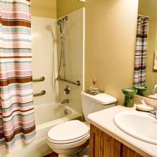 A cozy bathroom with a bathtub, shower, and striped curtain.