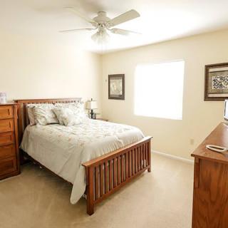 A cozy bedroom with wooden furniture and soft lighting.