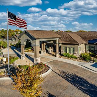 A scenic view of a building entrance with an American flag on a sunny day.