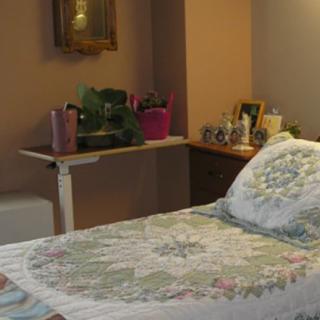 A cozy bedroom with a quilt-covered bed and decorative accents.