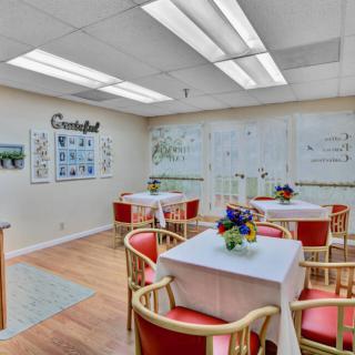 A cozy dining area with neatly arranged tables, chairs, and decorative elements.