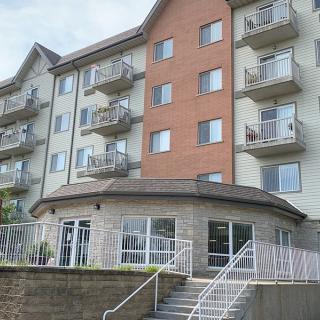A multi-story residential building with balconies and large windows.