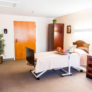 A well-equipped hospital room featuring a patient bed, furniture, and a calming interior.