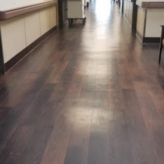 A view of a clean and well-lit wooden floor in a hallway.