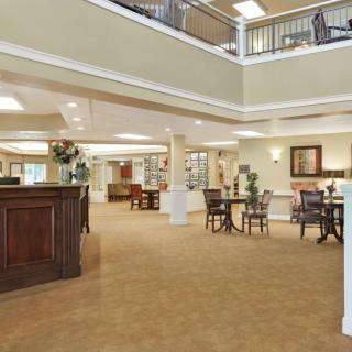 A spacious and well-lit lobby area with a reception desk, seating, and decorative elements.