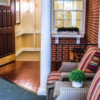Cozy lobby area with chairs and a potted plant near the entrance.