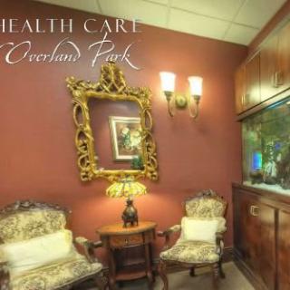 Cozy waiting area with elegant chairs, a decorative mirror, and a fish tank.