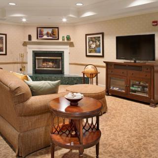A cozy living room with a fireplace, comfortable seating, and a television.