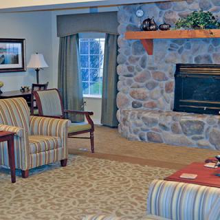 A cozy living room with a stone fireplace and comfortable seating.