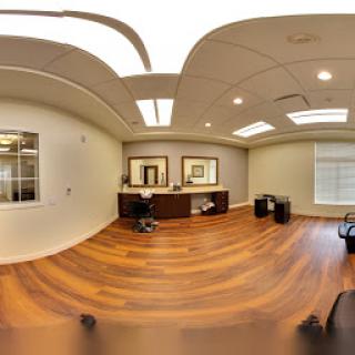 A modern office interior featuring wooden flooring and ample natural light.