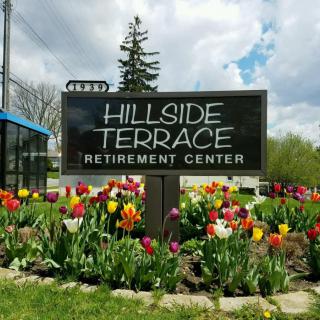 Hillside Terrace Retirement Center sign surrounded by colorful tulips.