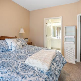 A cozy bedroom with a neatly made bed and connected bathroom.
