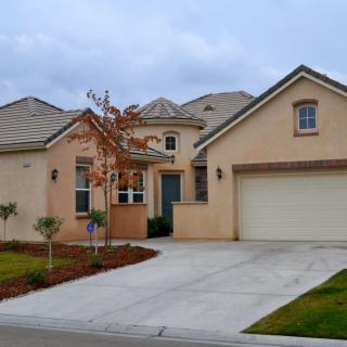 A suburban single-family home with a garage and landscaped front yard.
