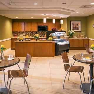 A modern cafe interior with tables, chairs, and a serving counter.