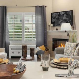 A cozy living room with a fireplace, comfortable seating, and decorative elements.