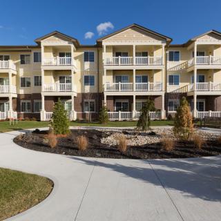 A modern apartment complex with landscaped grounds and multiple balconies.