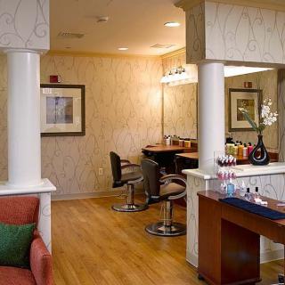 A modern salon interior with styling chairs, mirrors, and elegant decor.