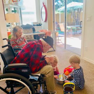 A heartwarming moment of interaction between a grandparent and young children, showing the beauty of family connections.