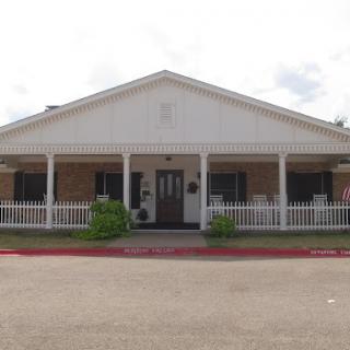 A welcoming residential building featuring a front porch and garden.