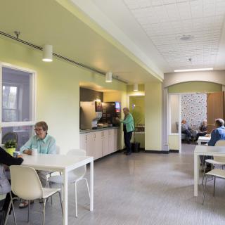 A modern cafeteria where people are enjoying their meals at tables.