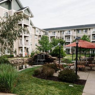 A serene courtyard with a garden and gazebo surrounded by apartment buildings.