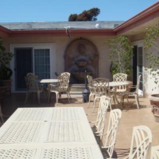 A sunny courtyard with outdoor seating and tables arranged around the patio.