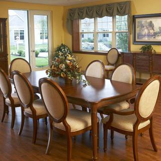 Elegant dining room with a wooden table and upholstered chairs.