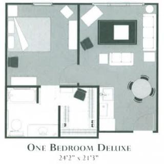 Floor plan of a One Bedroom Deluxe apartment highlighting furniture arrangement and room dimensions.