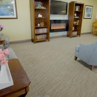 A cozy living room setup featuring shelves, a television, and comfortable seating.