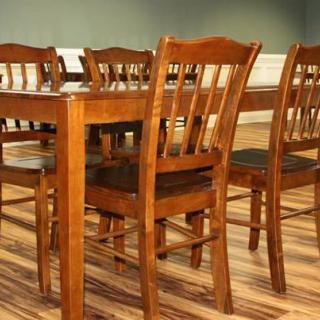 A wooden dining table set with multiple chairs in a well-lit dining room.