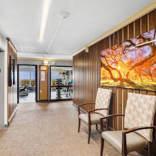 A modern hallway featuring wooden paneling and artwork, complemented by comfortable seating.