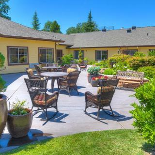 A sunny patio with comfortable seating and lush greenery.