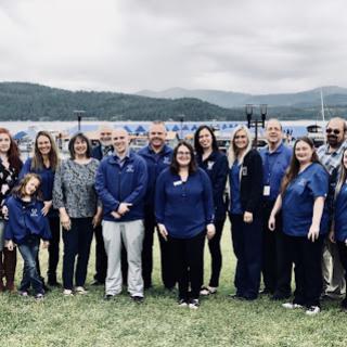 A team gathered outdoors in a scenic location, dressed in blue.
