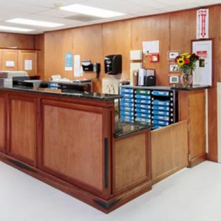 A neatly organized reception area with wooden paneling and office supplies.