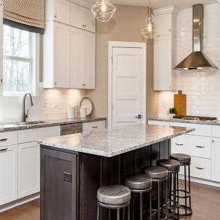 A modern kitchen with a central island and white cabinetry.