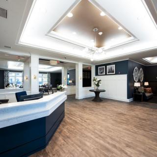A modern reception area with sleek design, featuring wooden floors and ceiling lights.