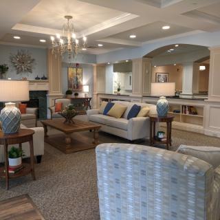 A cozy and elegantly decorated living room with comfortable seating, a central coffee table, and soft lighting.