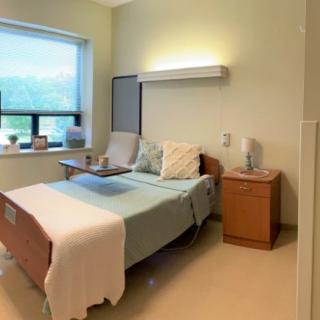 A clean and organized hospital room with a bed near a window.