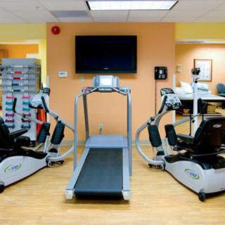 A small gym with a treadmill and exercise bikes.