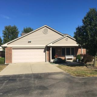 A suburban house with a driveway and garage on a clear day.