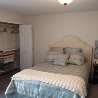 A cozy, well-arranged bedroom featuring a comfortable bed and a closet space.