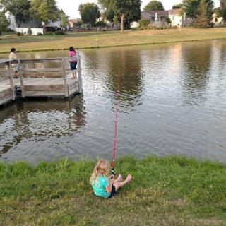 A young child enjoys a peaceful day of fishing by the water.