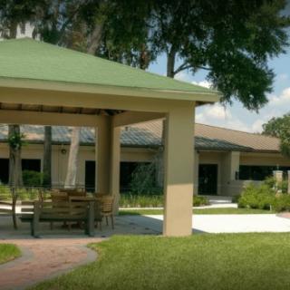 A peaceful outdoor area featuring a gazebo surrounded by lush greenery and trees.