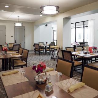 A well-lit dining area with neatly arranged tables and chairs.
