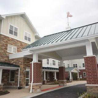 A modern residential building with a covered entrance and attractive architecture.