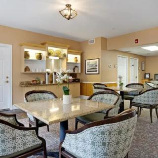 A cozy dining area with tables and chairs arranged neatly, featuring warm lighting and tasteful decor.