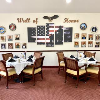 A dining area featuring a Wall of Honor with military tributes and an American flag theme.