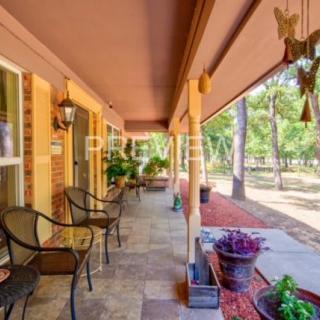 A cozy porch with chairs and potted plants overlooking a garden.